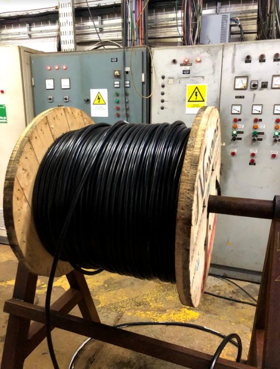 Carrete de cable junto a tableros eléctricos